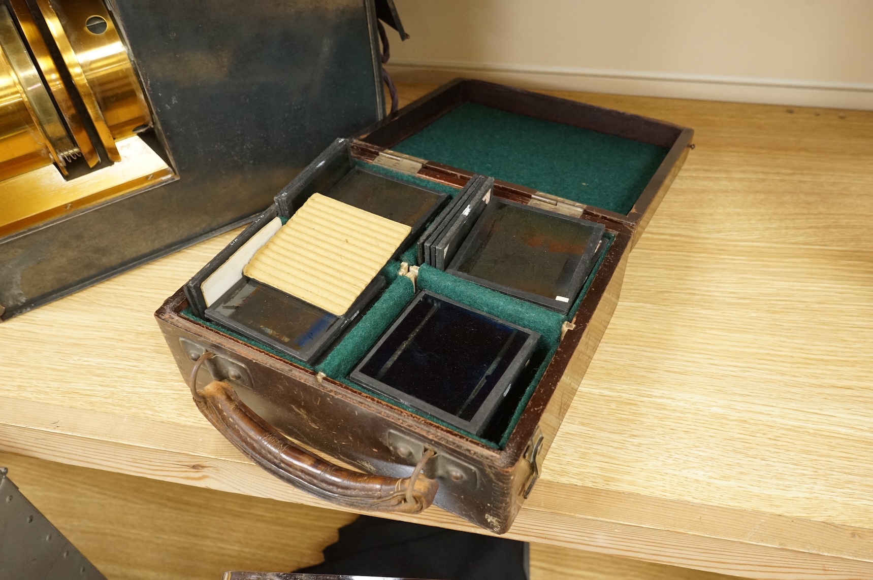 A tinplate and brass magic lantern, converted to an electric lamp and missing the original chimney, in a tin case, together with a case of slides, mostly biblical related.